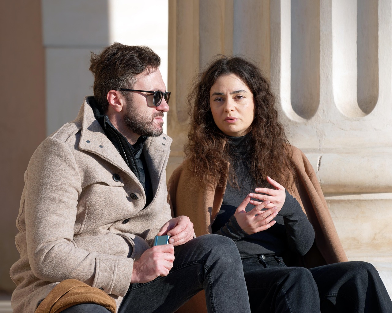 Siedząca para na dworze widać, że rozmawiają o czymś istotnym.