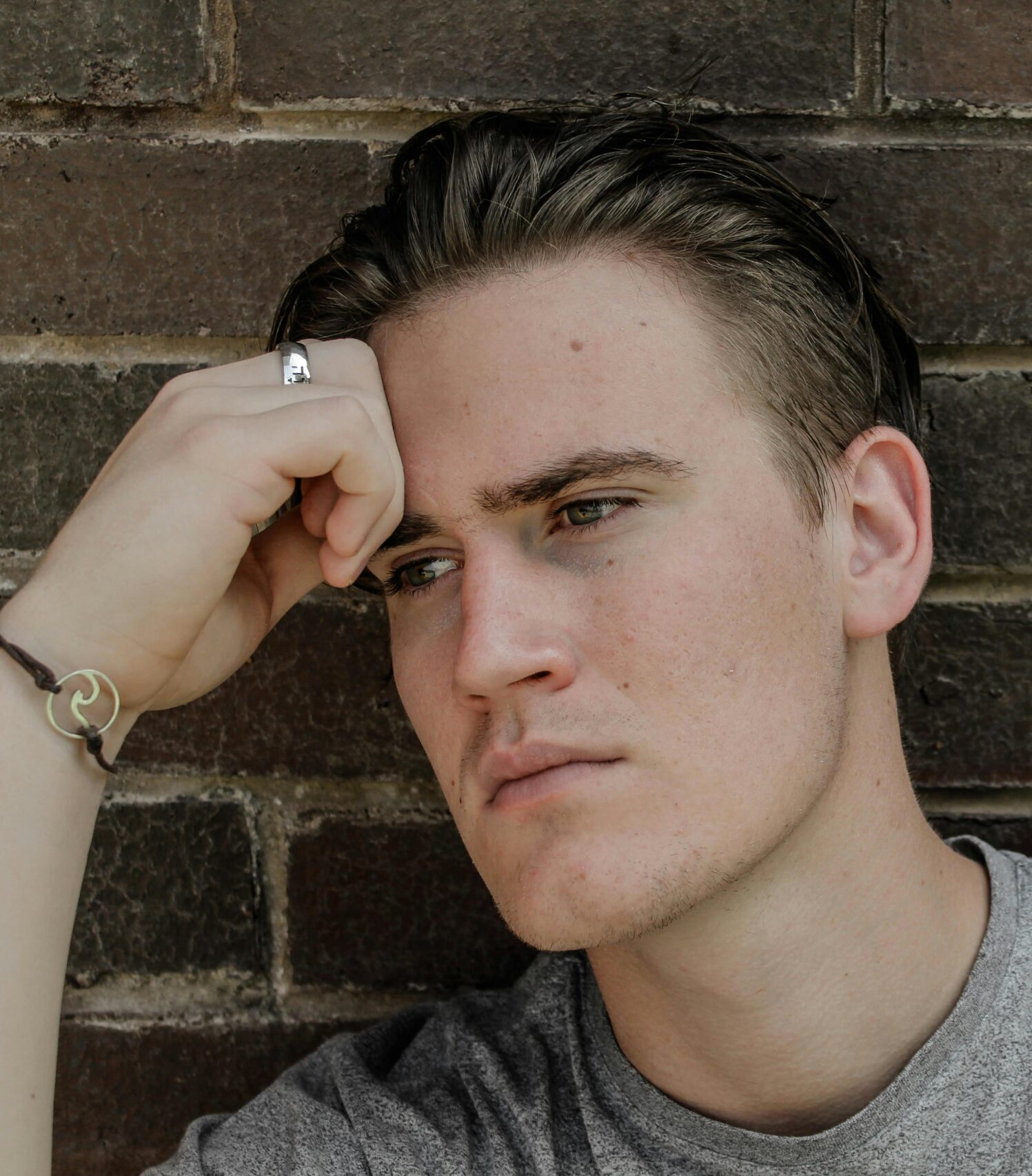 Młody mężczyzna wpatruje się przed siebie, ewidentnie poszukując pomocy w swojej relacji.