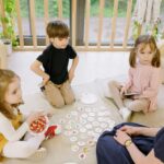 Group of children playing educational games indoors with a teacher.