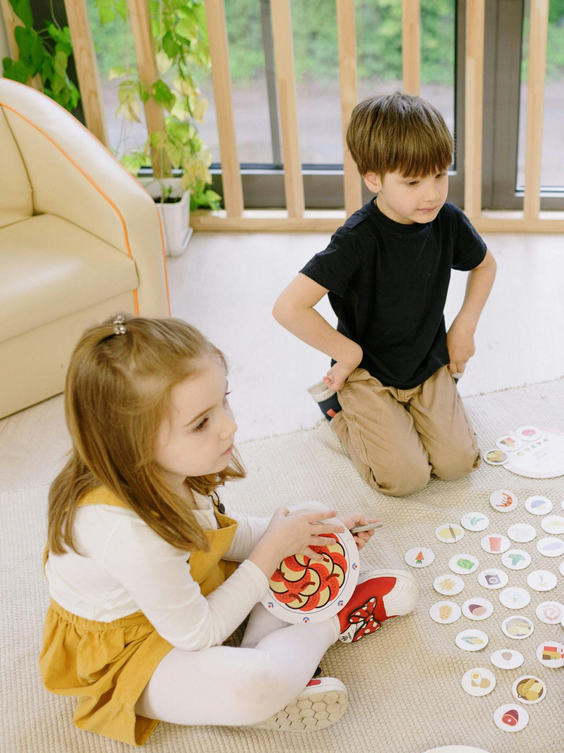 Group of children playing educational games indoors with a teacher.